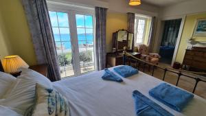 a bedroom with a bed with a view of the ocean at The White House in Saint Mawes