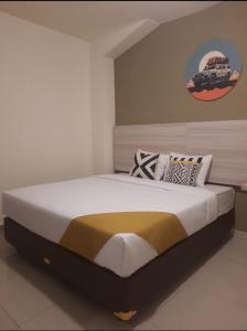 um quarto com uma cama grande e um camião na parede em Zester Hotel Sidoarjo em Sidoarjo