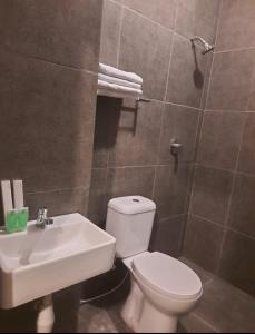 uma casa de banho com um WC branco e um lavatório. em Zester Hotel Sidoarjo em Sidoarjo