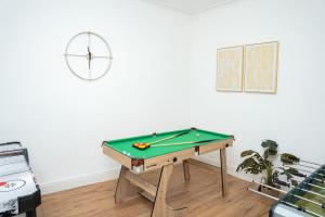 a room with a pool table and a clock on the wall at Large Ideal Accommodation for Groups & Contractors in Horsforth