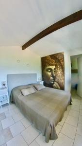 a large bed in a room with a large head on the wall at Résidence île de beauté in Propriano