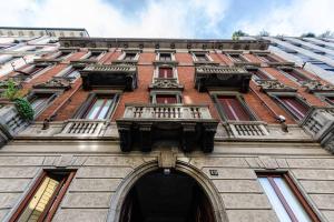 a tall brick building with an archway at Appartamento Cadorna in Milan