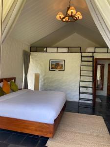 1 dormitorio con 1 cama con escalera y lámpara de araña en The Cliff Resort Pokhara Kushma en Kusma