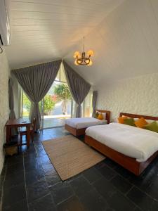 1 dormitorio con 2 camas y ventana en The Cliff Resort Pokhara Kushma en Kusma