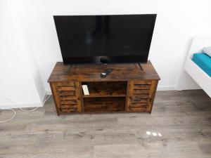 a flat screen tv on a wooden entertainment center at L8 Street-Kaiserslautern-Monteurwohnung-Worker's apartment in Kaiserslautern