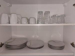 a shelf filled with plates and glass jars at L8 Street-Kaiserslautern-Monteurwohnung-Worker's apartment in Kaiserslautern