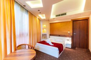 ein Hotelzimmer mit einem Bett und einem Tisch in der Unterkunft Hotel Luxor in Medgidia