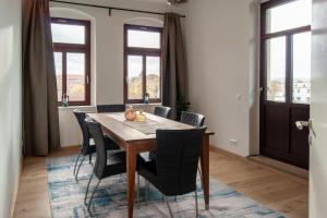 een eetkamer met een houten tafel en stoelen bij Große familienfreundliche Wohnung in Dresden in Dresden