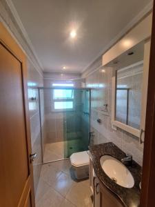 ein Bad mit einer Dusche, einem Waschbecken und einem WC in der Unterkunft A casa Amarela in Atibaia