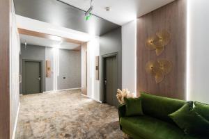 a living room with a green couch and a fan at Hotel Luxor in Medgidia