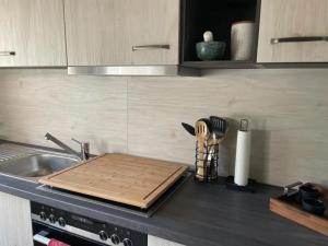 a kitchen counter with a cutting board and a sink at Apartment Bella Petit in Rinderbügen