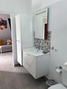 W białej łazience znajduje się umywalka i lustro. w obiekcie Finca la Gaviota - Terazza w mieście Icod de los Vinos