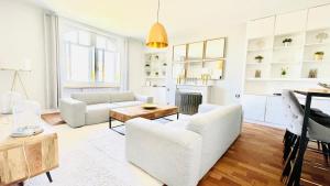 uma sala de estar com mobiliário branco e uma mesa em REIMS CATHEDRALE LUXURIOUS PROPERTY em Reims