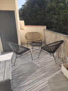 2 Stühle und ein Tisch auf der Terrasse in der Unterkunft Charmant appartement entier 4 pers proche Aix in Gardanne