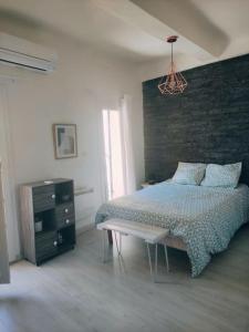 ein Schlafzimmer mit einem Bett und einer Ziegelwand in der Unterkunft Charmant appartement entier 4 pers proche Aix in Gardanne