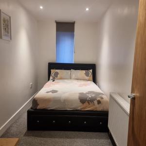 um pequeno quarto com uma cama no canto em 3 bed apartment in London Plumstead em Woolwich