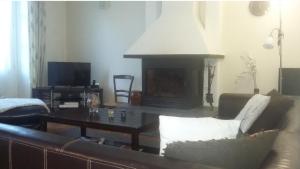 a living room with a couch and a table with a fireplace at Appartement FARIO in Ax-les-Thermes
