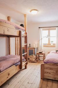 a bedroom with two bunk beds and a desk at Berggasthaus & Lodge Resterhöhe in Mittersill