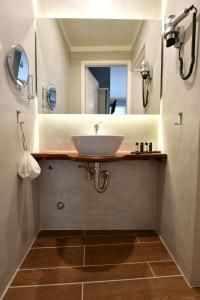 ein Bad mit einem Waschbecken und einem Spiegel in der Unterkunft Piteoussa rooms in Hydra