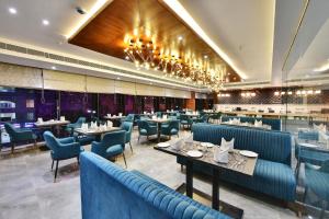 a dining room with blue chairs and tables at The Fern Residency Ajmer in Ajmer