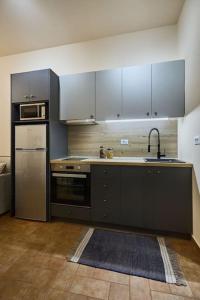 a kitchen with gray cabinets and a sink and refrigerator at Διαμέρισμα σε διατηρητέο κτίριο in Chalkida