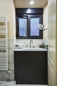 a bathroom with a sink and a window at Διαμέρισμα σε διατηρητέο κτίριο in Chalkida