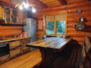 a kitchen with a wooden table in a cabin at Дерев'яний котедж "Казка" in Yaremche