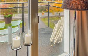 deux bougies assises sur une table devant une fenêtre dans l'établissement Gorgeous Apartment In Huskvarna With Kitchen, à Huskvarna