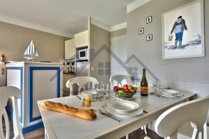 kuchnia i jadalnia ze stołem i krzesłami w obiekcie LocaLise - A06 - Entièrement de plain-pied avec petite vue mer - Donnant sur la piscine et le jardin - wifi inclus - draps inclus - w mieście Guilvinec