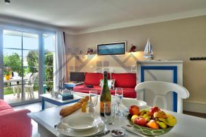 salon ze stołem i miską owoców w obiekcie LocaLise - A06 - Entièrement de plain-pied avec petite vue mer - Donnant sur la piscine et le jardin - wifi inclus - draps inclus - w mieście Guilvinec