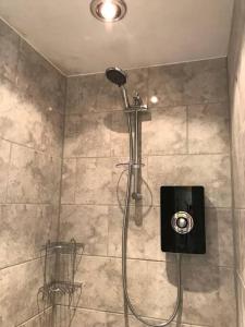 une douche avec pommeau de douche dans une salle de bain dans l'établissement Forestry Cottage. Hot tub, open fire, dog friendly, à Gaywood