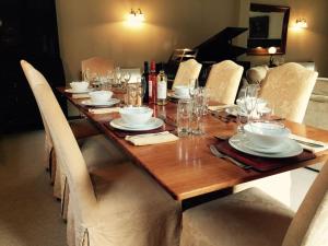 d'une table en bois avec des chaises, des assiettes et des verres. dans l'établissement Forestry Cottage. Hot tub, open fire, dog friendly, à Gaywood 29 autres photos