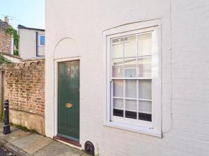uma porta verde e uma janela num edifício de tijolos em Host & Stay - St Radigunds House em Canterbury