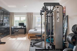 een kamer met een fitnessruimte met een bed en een bureau bij Brussels Penthouse Prestige in Brussel