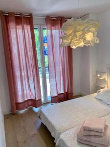 a bedroom with red curtains and a bed and a chandelier at PISO CENTRICO CON PATIO PRIVADO in Madrid