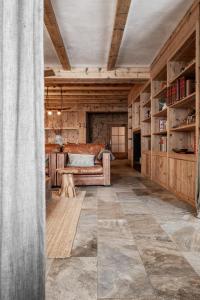 a living room with a couch and bookshelves at Berggasthaus & Lodge Resterhöhe in Mittersill