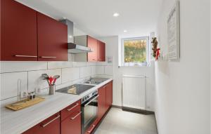 a kitchen with red cabinets and a sink at 1 Bedroom Lovely Apartment In Nieheim in Nieheim