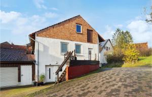 a white house with a brick roof and a driveway at 1 Bedroom Lovely Apartment In Nieheim in Nieheim