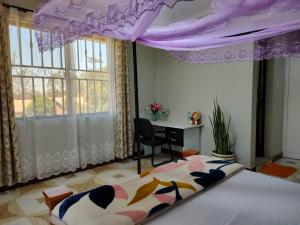 um quarto com uma cama de dossel roxo em Keeney House at St. Gabriel's em Arusha