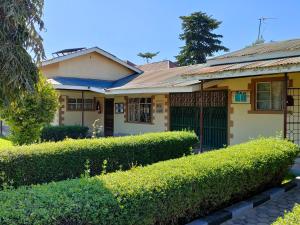 een huis met groene heggen ervoor bij Keeney House at St. Gabriel's in Arusha