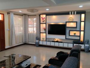uma sala de estar com uma grande televisão de ecrã plano em Keeney House at St. Gabriel's em Arusha