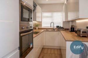 a kitchen with a sink and a stove top oven at Modernised House Close To City Centre in Southampton