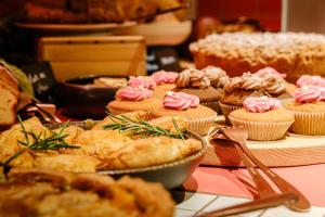 Ein Haufen Gebäck und Kuchen auf dem Tisch. in der Unterkunft Hôtel Tandem - Boutique Hôtel in Straßburg