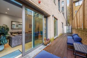 eine Terrasse mit einem Sofa und einem Tisch in der Unterkunft Large Modern One Bedroom Apartment (nearly 800 ft) in London