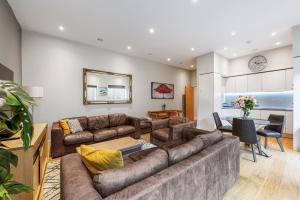 a living room with a couch and a table at Large Modern One Bedroom Apartment (nearly 800 ft) in London