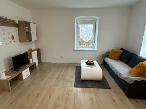 ein Wohnzimmer mit einem Sofa und einem Tisch in der Unterkunft Appartement Niederthalheim 