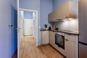 cocina con fregadero y fogones horno superior en Balthasar Neumann Apartment - by homekeepers, en Würzburg
