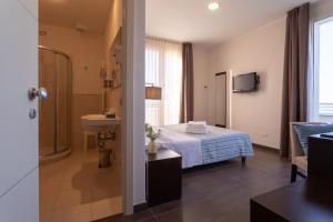 a bathroom with a bed and a sink in a room at Gimmi Hotel in Rimini