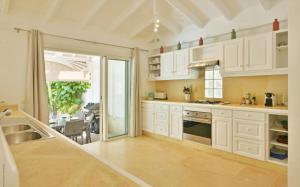 a large kitchen with white cabinets and a dining room at Saint Barth Villa 1 in Saint-Jean