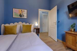 Un dormitorio con una cama blanca y una pared azul. en homie stay Balthasar, en Würzburg 3 fotos más